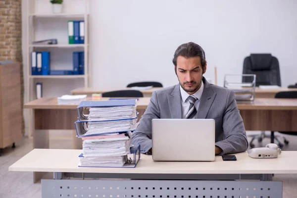 Young male employee unhappy with excessive work in the office — Stock Photo, Image