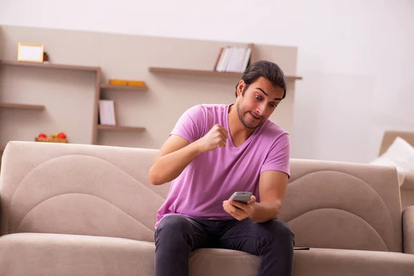 Jeune homme regardant la télévision à la maison pendant la pandémie — Photo