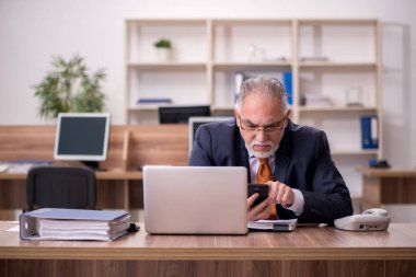 Ofiste çalışan yaşlı bir erkek.