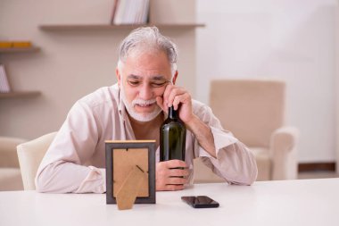 Evde alkol alan yaşlı bir dul.