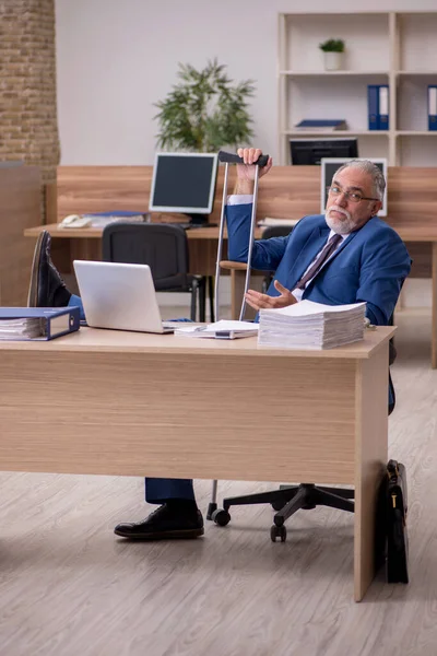 Old businessman employee after accident working in the office — Stock Photo, Image