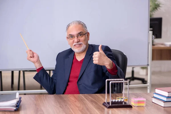 Antigo professor físico sentado na sala de aula — Fotografia de Stock