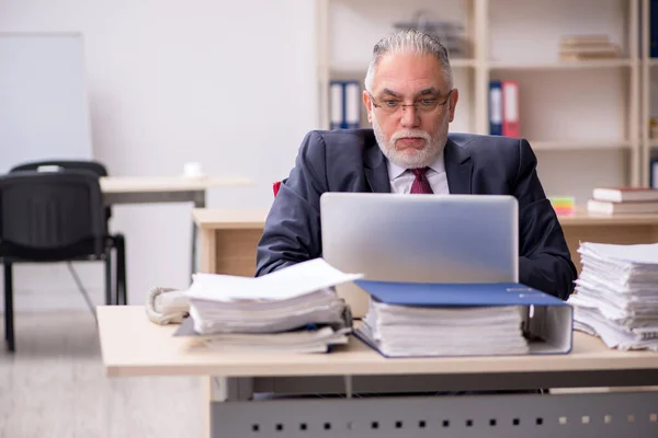 Dipendente di sesso maschile anziano e troppo lavoro sul posto di lavoro — Foto Stock