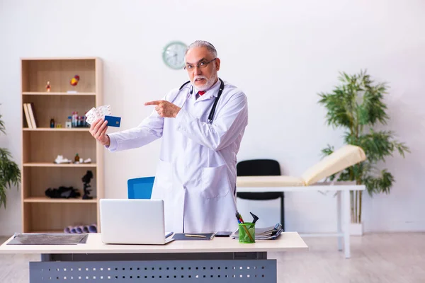 Velho médico masculino segurando cartão de crédito — Fotografia de Stock