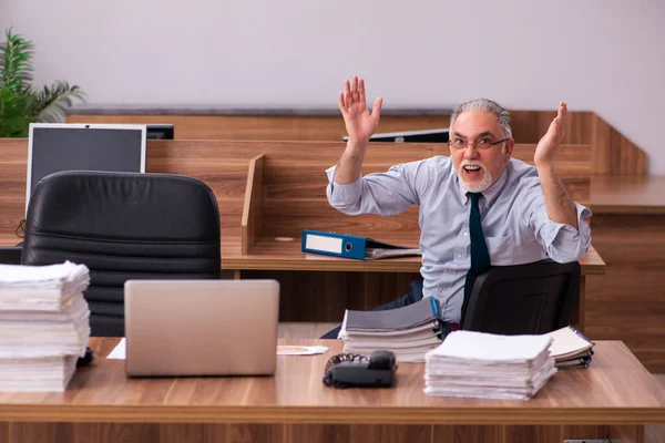 Velho empregado masculino e muito trabalho no escritório — Fotografia de Stock