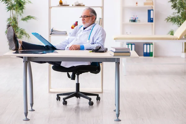 Alter Arzt macht sich Notizen in der Klinik — Stockfoto