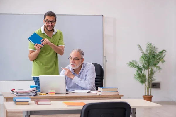 Old male teacher and young male student in the classroom — Stock Photo, Image