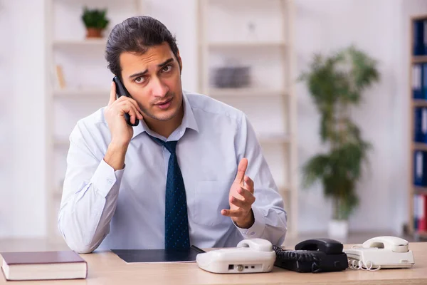 Unga manliga call center operatör som arbetar vid sitt skrivbord — Stockfoto