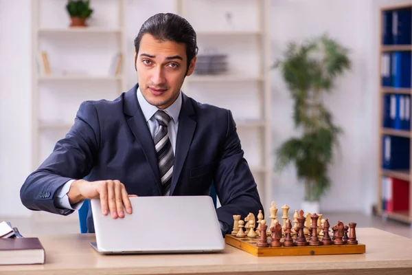 Jeune employé masculin jouant aux échecs sur le lieu de travail — Photo