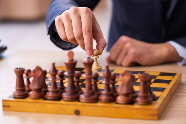 Молодий працівник чоловічої статі грає в шахи на робочому місці — стокове фото