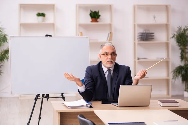 Velho empregador masculino na frente do quadro branco — Fotografia de Stock