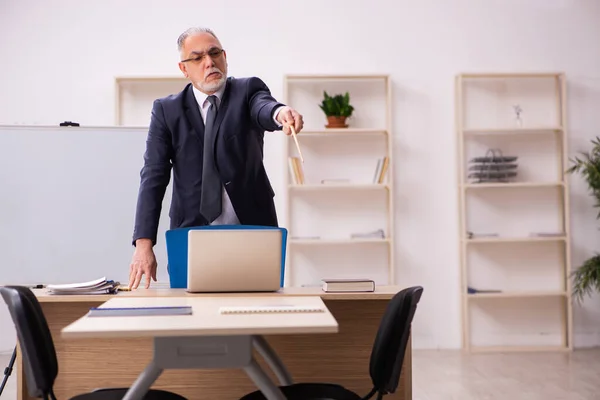 Velho empregador masculino na frente do quadro branco — Fotografia de Stock