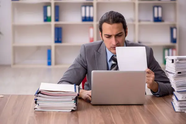 Jovem funcionário masculino infeliz com excesso de trabalho no escritório — Fotografia de Stock