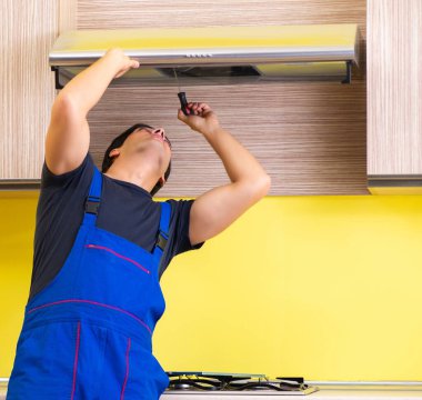 Genç müteahhit mutfak mobilyalarını monte ediyor.