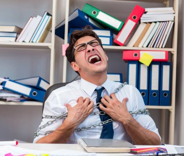 Çalışan zincirle masasına bağlanmış ve zincirlenmiş.