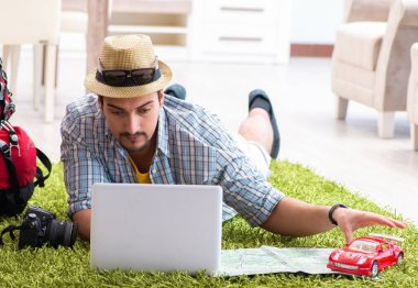 Genç adam internetten seyahat etmeyi planlıyor.