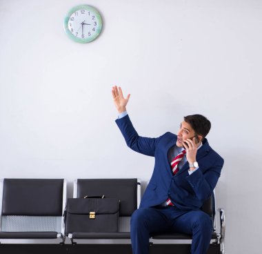 Havaalanı dinlenme odasında yolcu bekleyen adam.