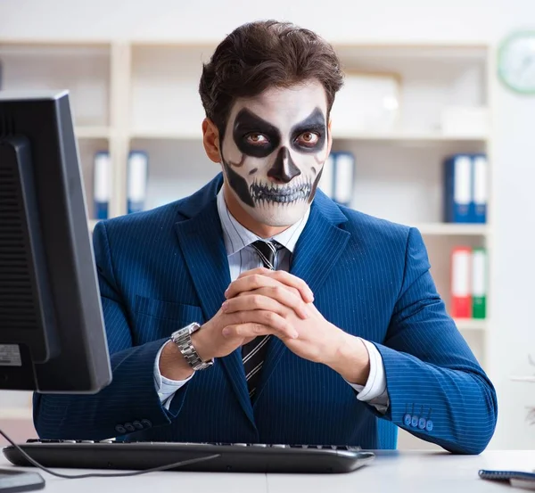 Businessmsn con maschera viso spaventoso che lavora in ufficio — Foto Stock