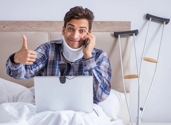 Homem ferido conversando online via webcam na cama em casa — Fotografia de Stock