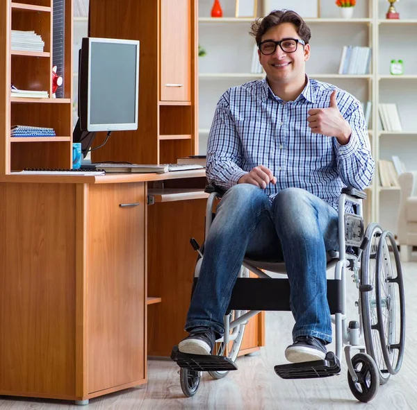 Gehandicapte student die thuis in een rolstoel studeert — Stockfoto
