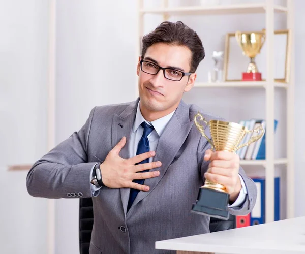 Empresario con copa de premio por logros en el cargo — Foto de Stock