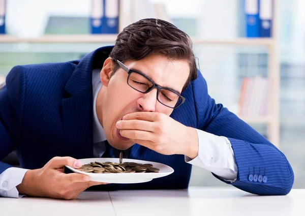 オフィスで金貨を食べる面白いビジネスマン — ストック写真
