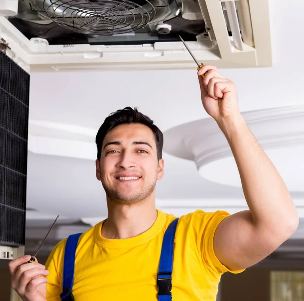 Reparador reparando la unidad de aire acondicionado del techo — Foto de Stock