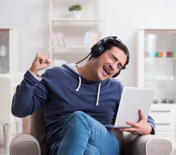 Jonge knappe man die naar muziek luistert met koptelefoon — Stockfoto