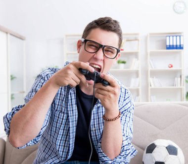 Genç adam evde bilgisayar oyunu oynuyor.