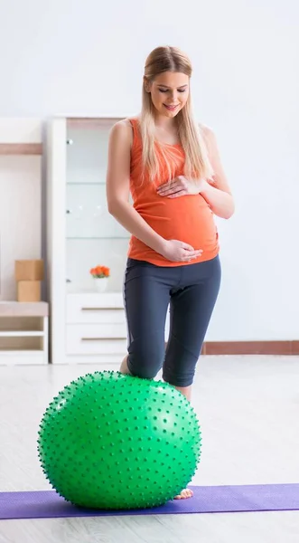 Молодая женщина готовится к родам упражнения на дому — стоковое фото