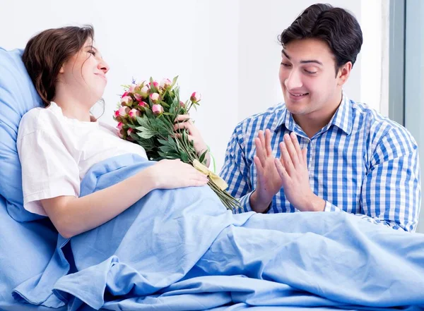 Opiekuńczy kochający mąż odwiedzający ciężarną żonę w szpitalu — Zdjęcie stockowe