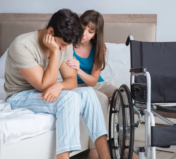 Desperate man on wheelchair with his sad wife