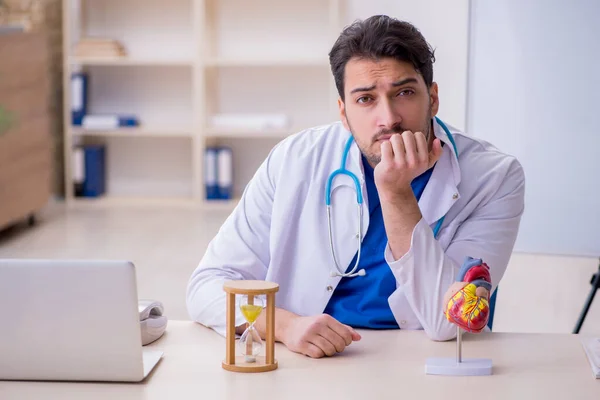 Jovem médico cardiologista no conceito de gerenciamento de tempo — Fotografia de Stock