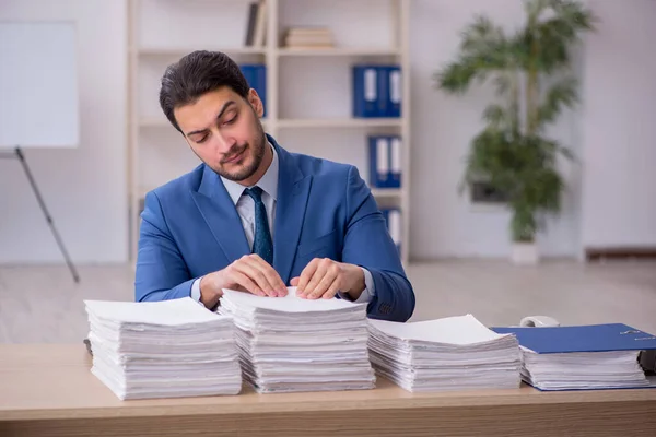 Young male employee unhappy with excessive work in the office — Stock Photo, Image