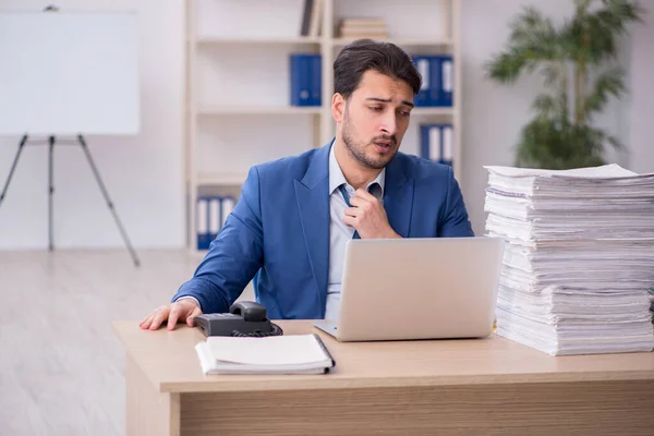 Junge männliche Angestellte unzufrieden mit exzessiver Arbeit im Büro — Stockfoto