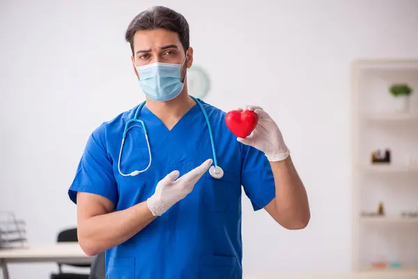 Ung manlig läkare kardiolog arbetar på kliniken under pand — Stockfoto