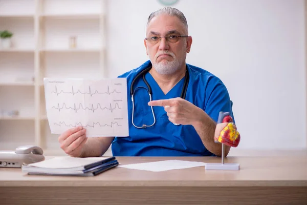 나이든 남성 심장 전문의 가클리닉에서 일하고 있다 — 스톡 사진