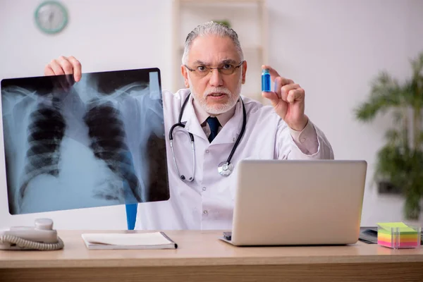 Gammal manlig röntgenläkare som arbetar på kliniken — Stockfoto