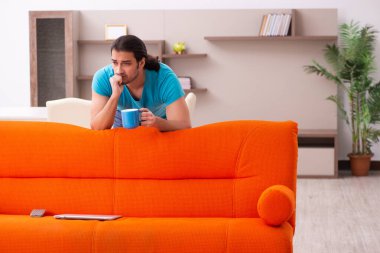 Genç erkek öğrenci salgın sırasında evde oturuyor.