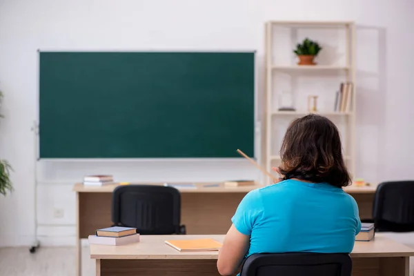 Joven estudiante masculino frente al tablero verde —  Fotos de Stock