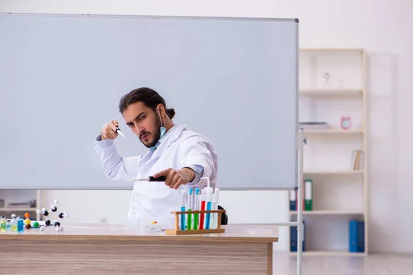 Sınıfta oturan genç erkek kimya öğretmeni. — Stok fotoğraf