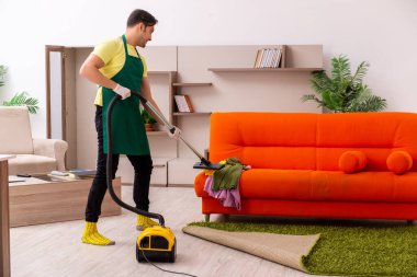 Genç müteahhit evin içini temizliyor.