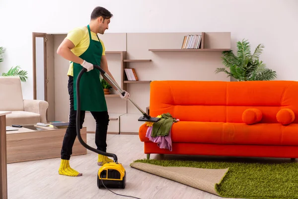 Jovem empreiteiro limpando a casa dentro de casa — Fotografia de Stock