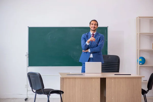 Jovem professor de terno na frente do quadro verde — Fotografia de Stock