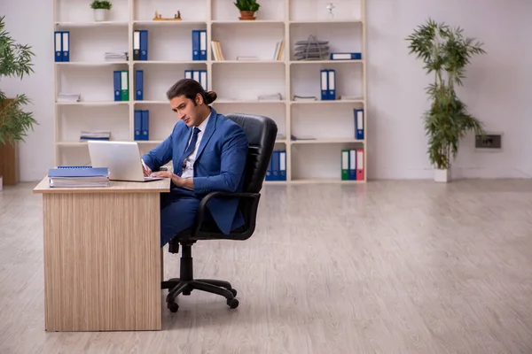 Junge männliche Angestellte sitzen im Büro — Stockfoto