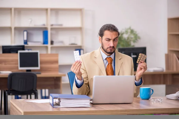 Malade employé masculin travaillant dans le bureau — Photo