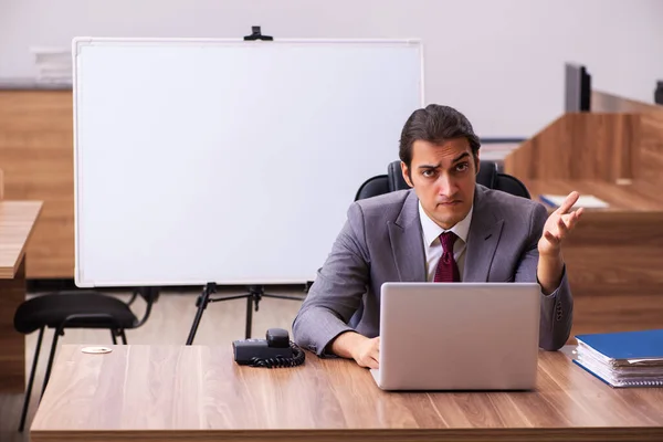 Young male business trainer in the office during pandemic