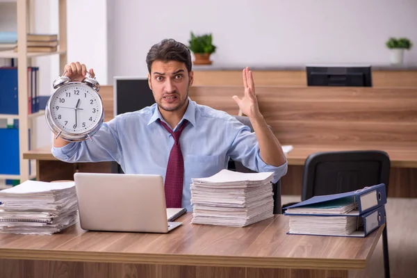 Jovem funcionário masculino infeliz com excesso de trabalho no escritório — Fotografia de Stock