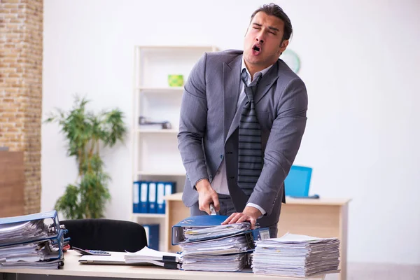 Jovem funcionário irritado com excesso de trabalho segurando faca — Fotografia de Stock