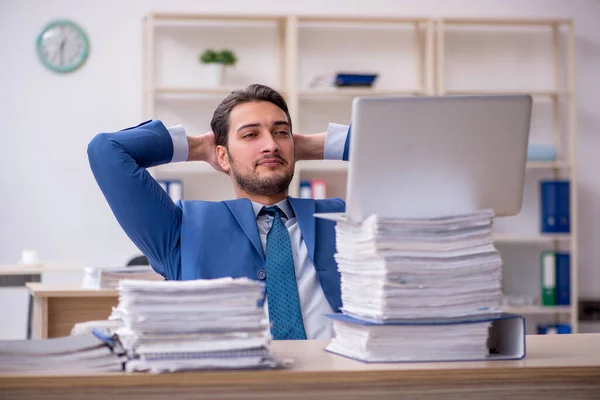 Empleado joven de negocios y demasiado trabajo en la oficina — Foto de Stock